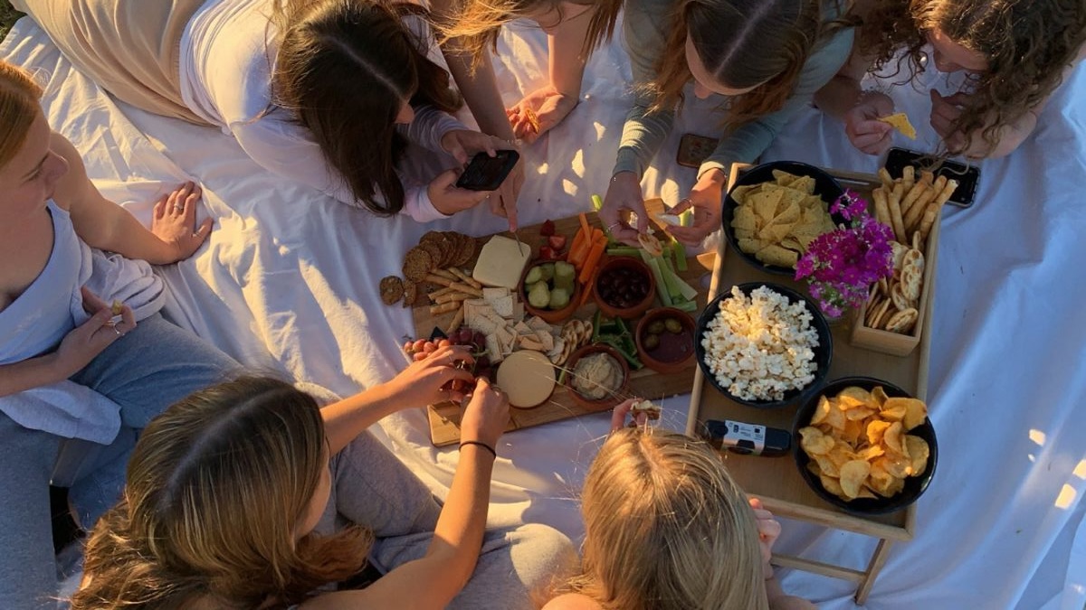 Grup de fete la picnic pe un cearceaf alb
